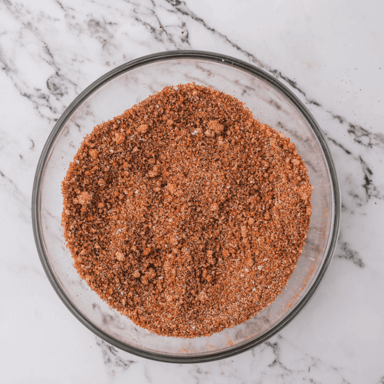 Pumpkin pie spice blend being whisked together in a small white bowl