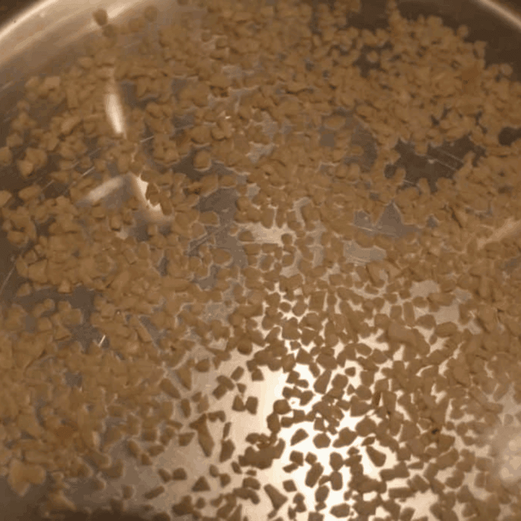 Adding white wine, water, and minced garlic to the Instant Pot for steaming clams.