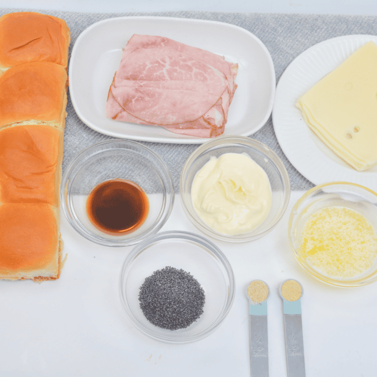 Ingredients for air fryer Hawaiian ham and cheese sliders laid out on a wood board.