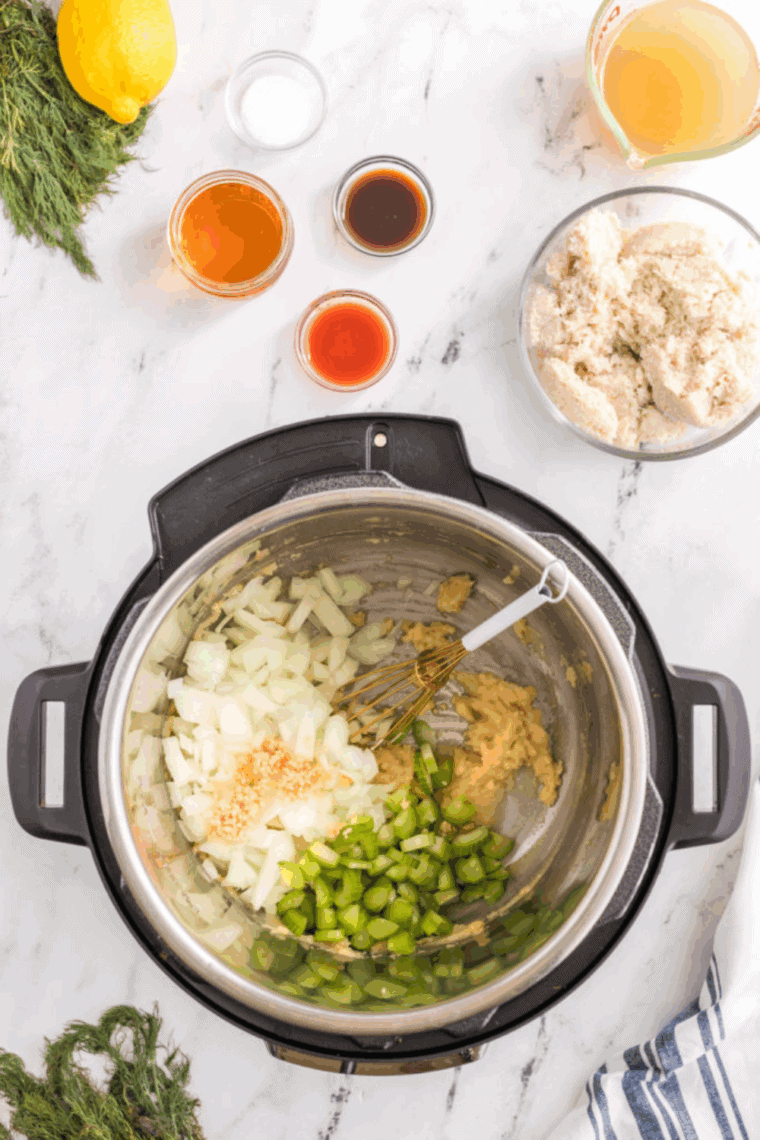 Saut&eacute;ing onions, celery, and garlic in the Instant Pot until softened