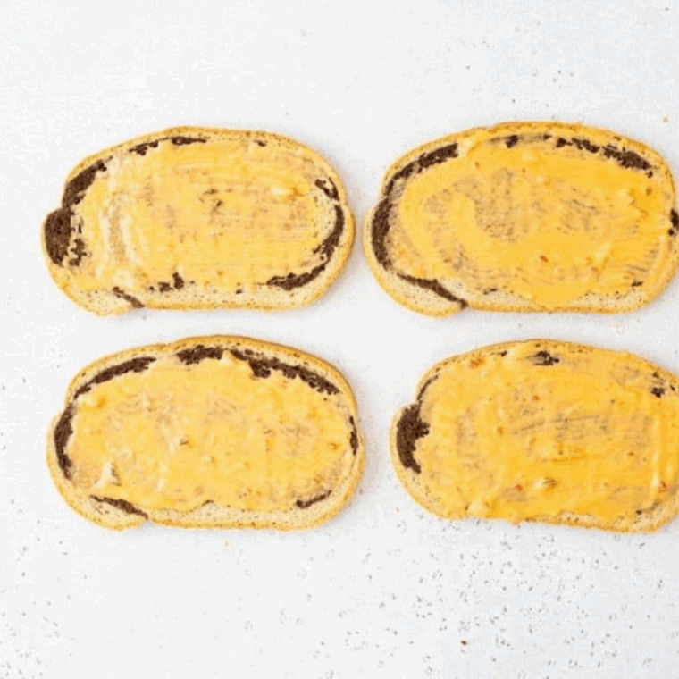 Spreading creamy Russian dressing evenly on slices of bread.