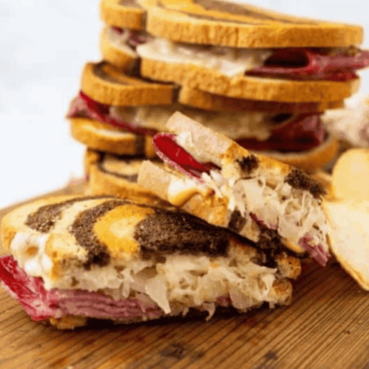 Air fryer Reuben sandwich with golden crispy bread, melted Swiss cheese, corned beef, sauerkraut, and Russian dressing.