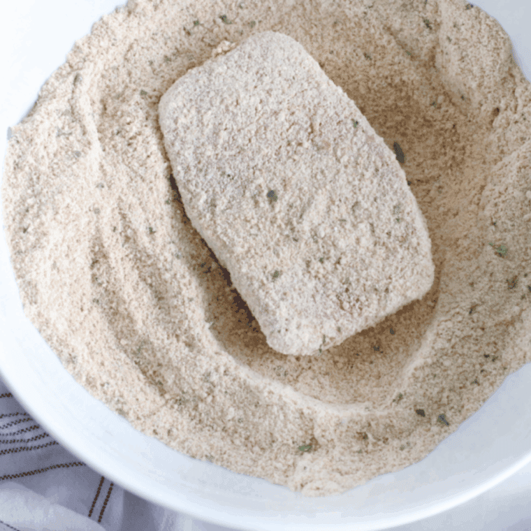 Preheat Ninja Foodi, tenderize pork chops with fork, then coat in egg and breadcrumb mixture.