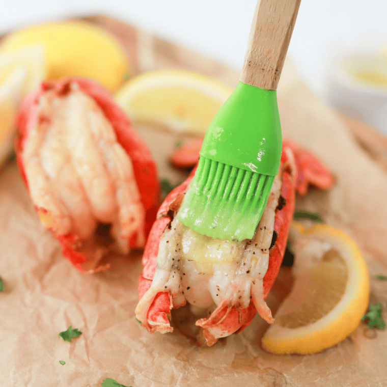 Air fryer lobster tails topped with lemon garlic butter and fresh parsley