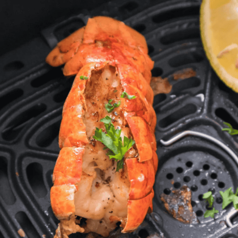 Close up of lobster tails cooked in the air fryer with melted garlic butter