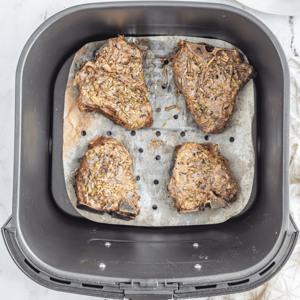 Lamb chops cooking in air fryer until browned