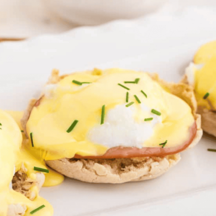 Assembled Air Fryer Eggs Benedict topped with hollandaise and chives.