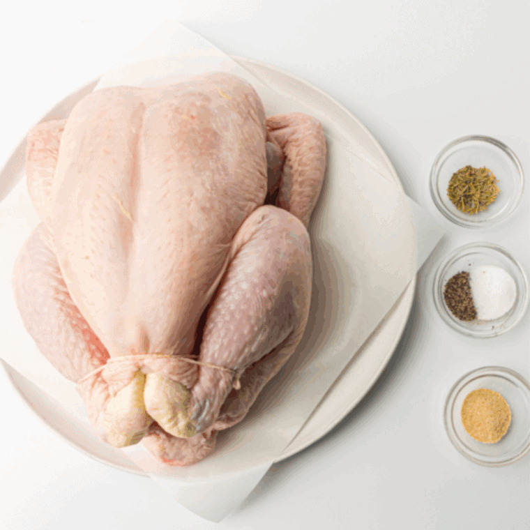 Preheating oven to 375°F and a whole chicken being patted dry with paper towels to ensure crispy skin.