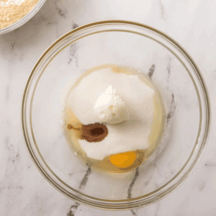 Eggs, sugar, shortening, and vanilla being mixed together in a large bowl
