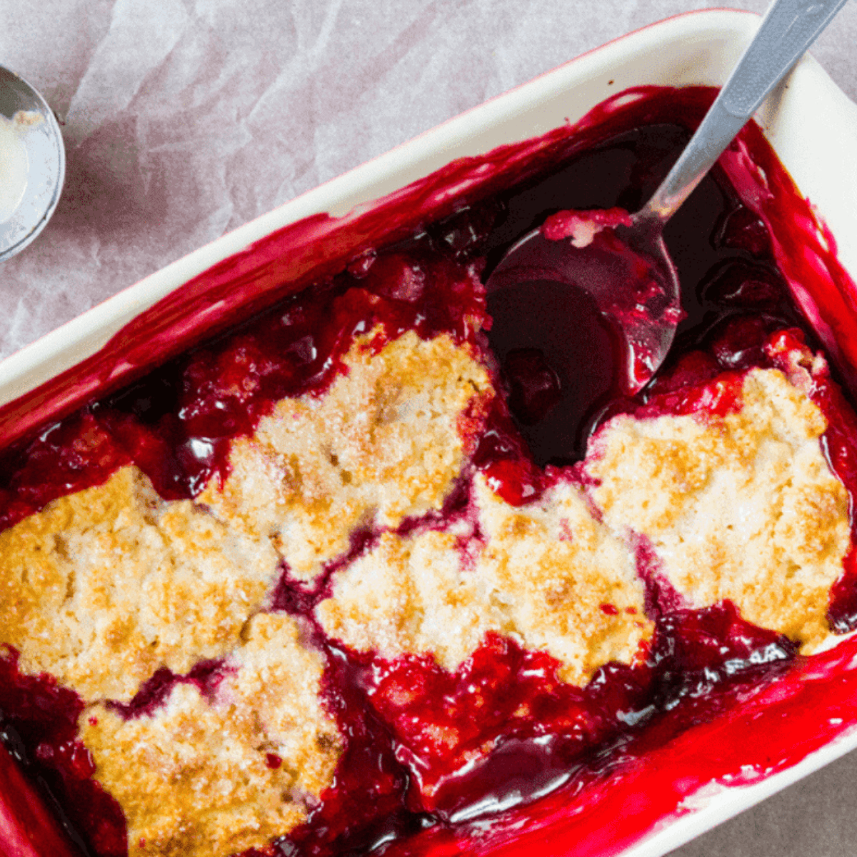 Golden cherry cobbler in an air fryer-safe dish with juicy cherries and crumbly topping