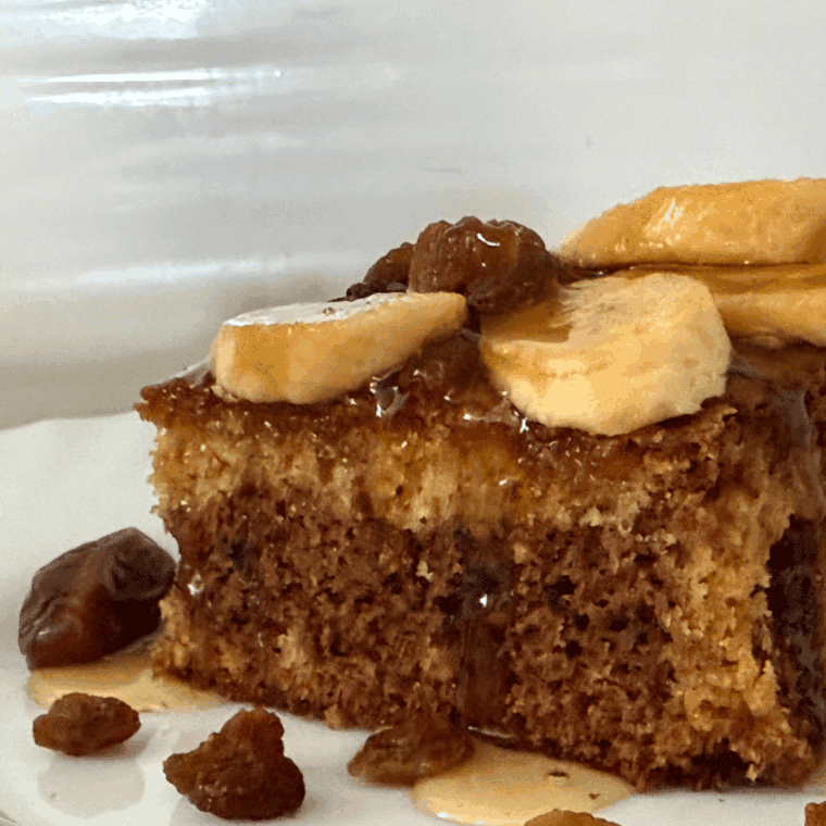 Air Fryer Date and Walnut Bread sliced on a wooden cutting board with walnuts scattered around