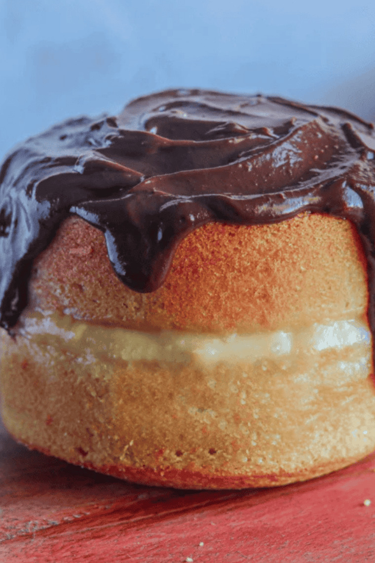 Air Fryer Boston Cream Pie with custard filling and chocolate glaze, served on a white plate, ready to enjoy.