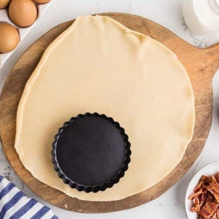 mini tart pan on rolled out circle of pie dough