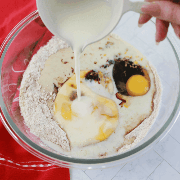 Mixing dry gingerbread ingredients with softened butter in bowl