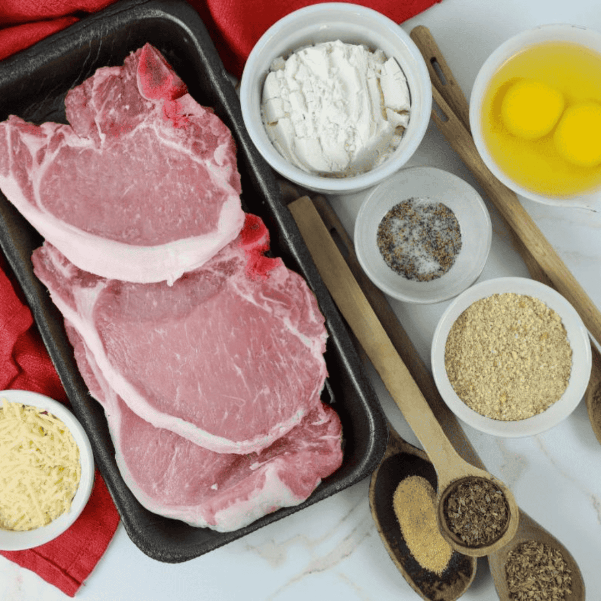 Ingredients needed for Easy Applebee's Parmesan Pork Chops Recipe on kitchen table.