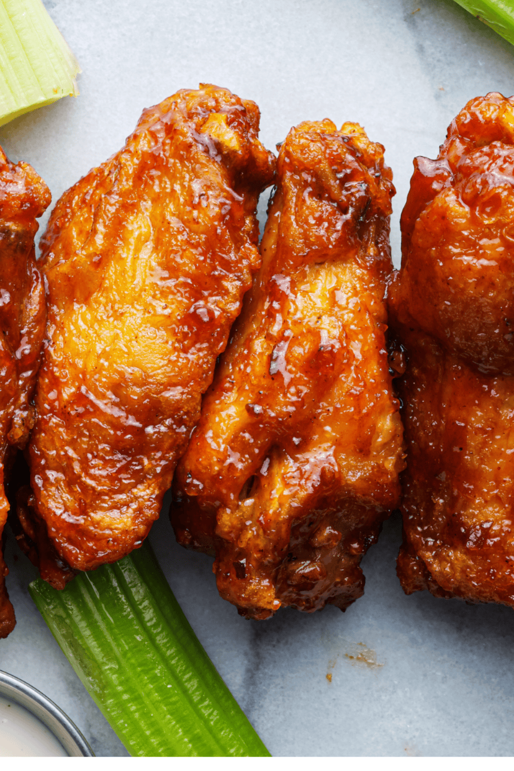 Close-up of crispy air fried chicken wings fresh from the basket served hot on a plate.