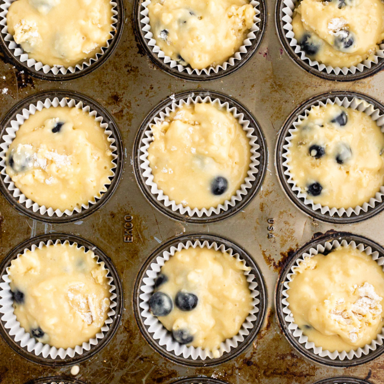 Silicone muffin cups filled with batter and topped with cinnamon streusel