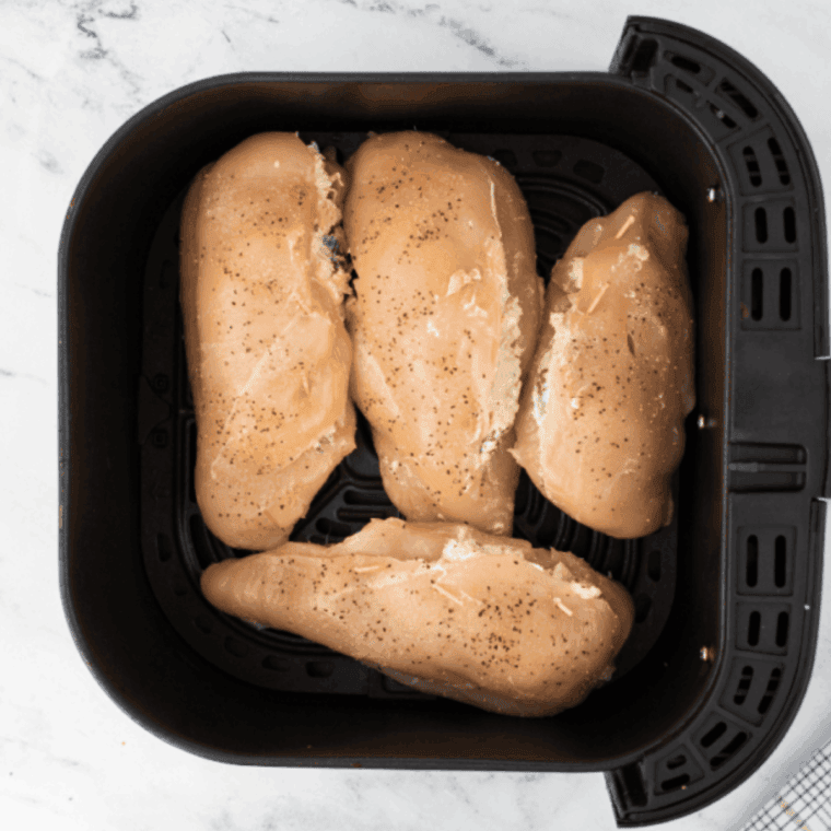 Cooking stuffed chicken breasts in the air fryer at 375°F until golden and fully cooked.