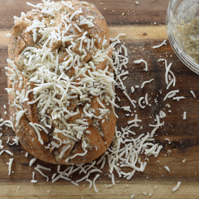 Sub rolls sliced in half lengthwise with cheesy garlic mixture spread over the cut sides