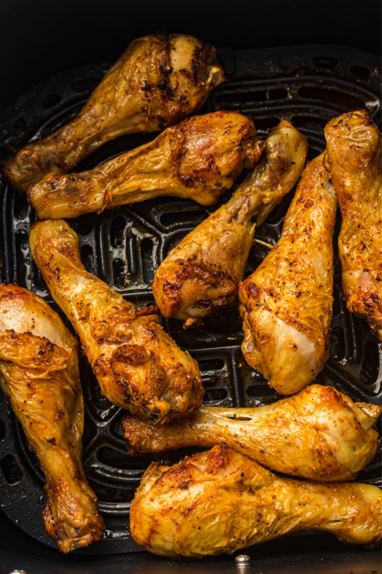 Close-up of crispy garlic paprika chicken drumsticks in an air fryer basket