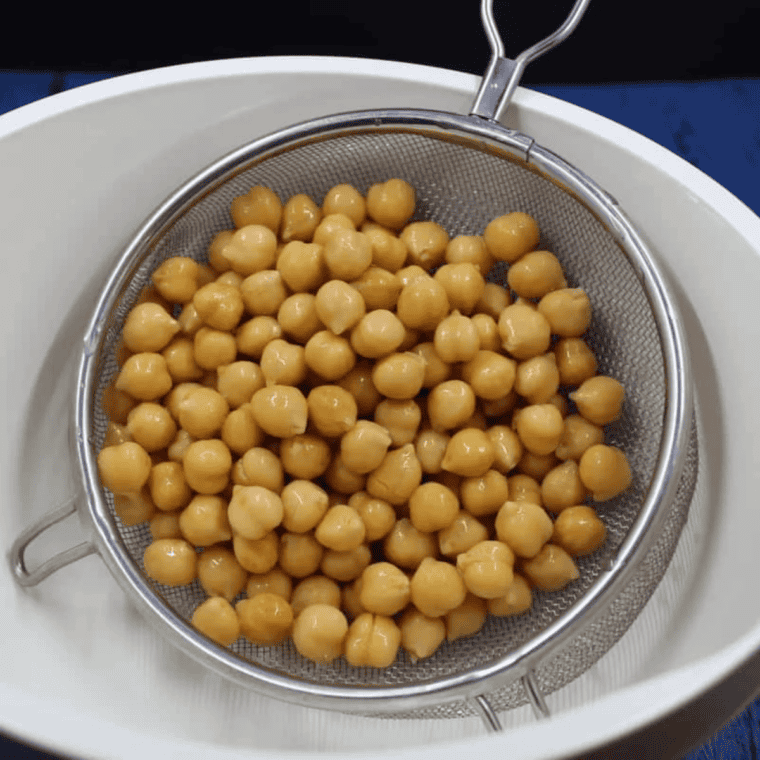 Rinsed chickpeas being patted dry with a paper towel.