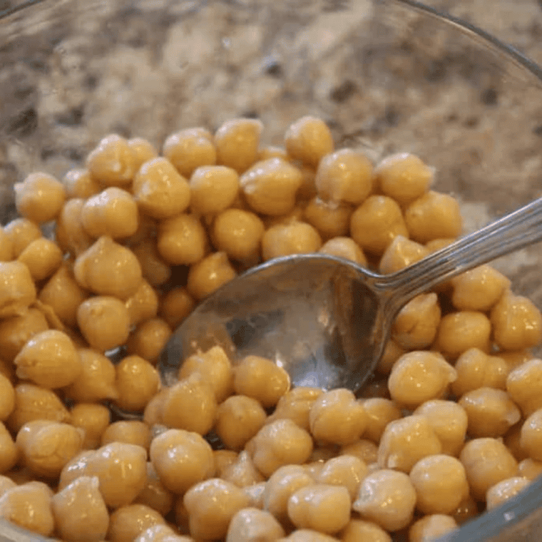 Chickpeas tossed with olive oil, cinnamon, and sugar in a bowl