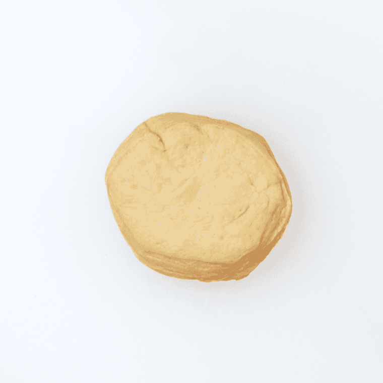 Buttermilk biscuit dough placed on a lightly floured surface before rolling