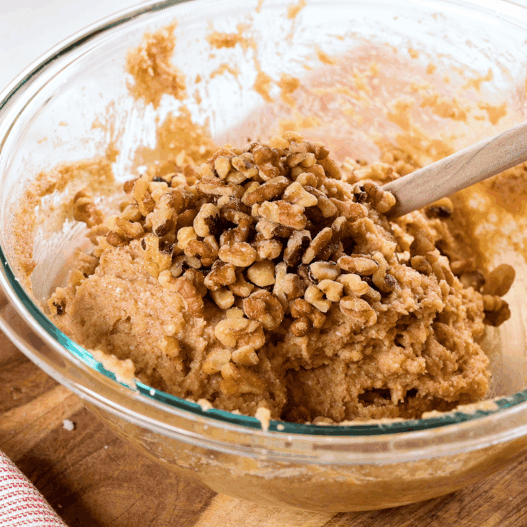 Folding chopped walnuts into smooth banana muffin batter for Air Fryer Banana Nut Muffins
