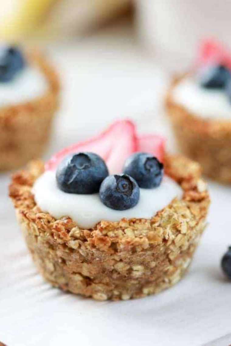 Air fryer oatmeal bites topped with yogurt and fresh berries on a white plate