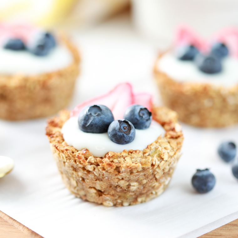 Air fryer oatmeal bites topped with yogurt and fresh berries on a white plate