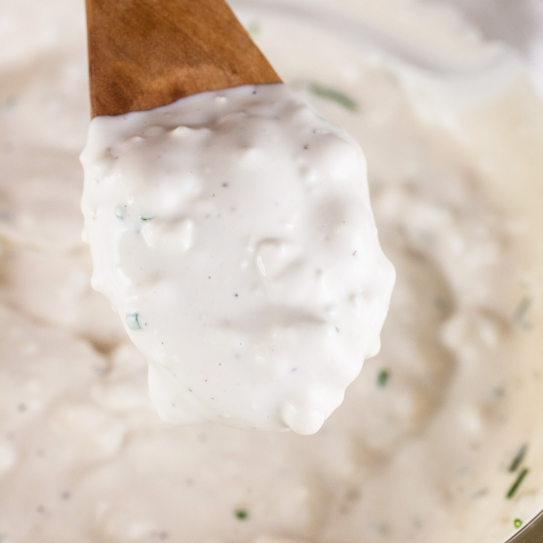Whisking homemade ranch dip with mayonnaise, sour cream, buttermilk, and herbs for Chili's Texas Cheese Fries