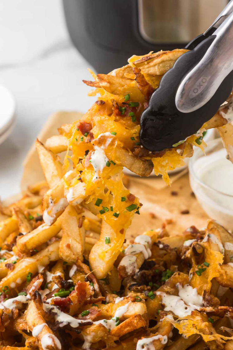 Finished Chili's Texas Cheese Fries topped with jalapeño slices and green onions, served with ranch