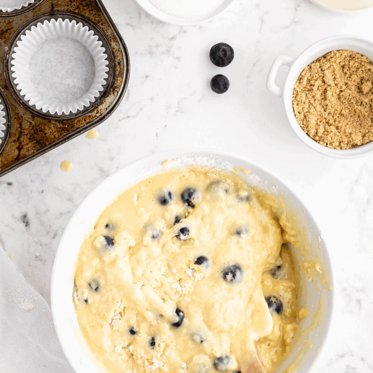 Folding fresh blackberries into muffin batter and filling greased or lined muffin cups about three-quarters full