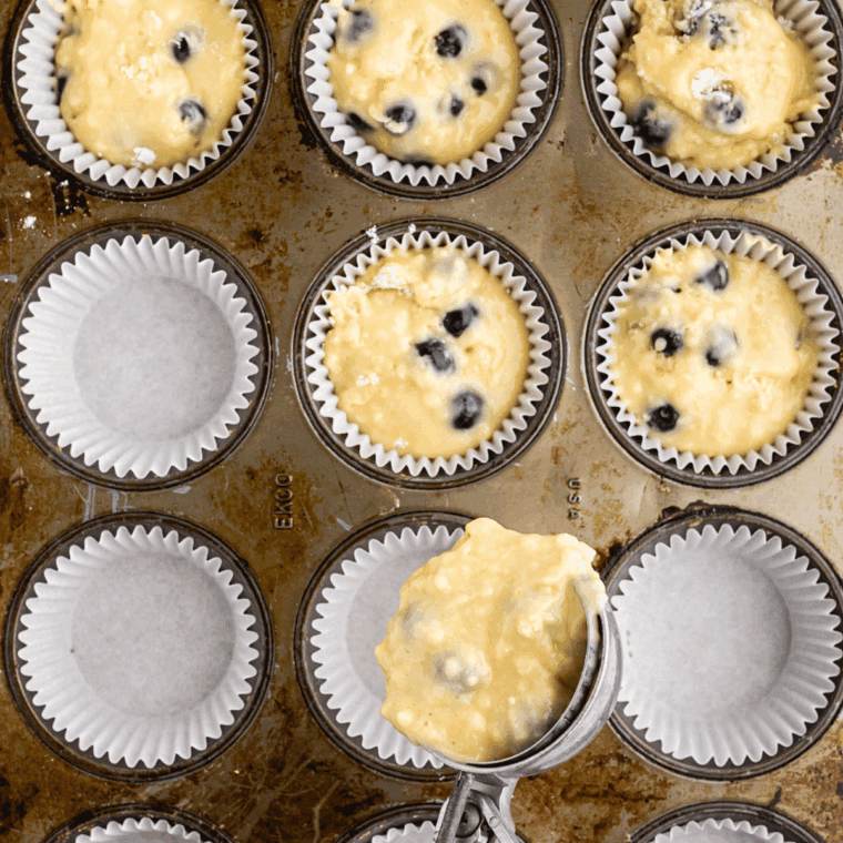 Muffin tin in air fryer baking muffins at 320&deg;F, checking doneness with a toothpick