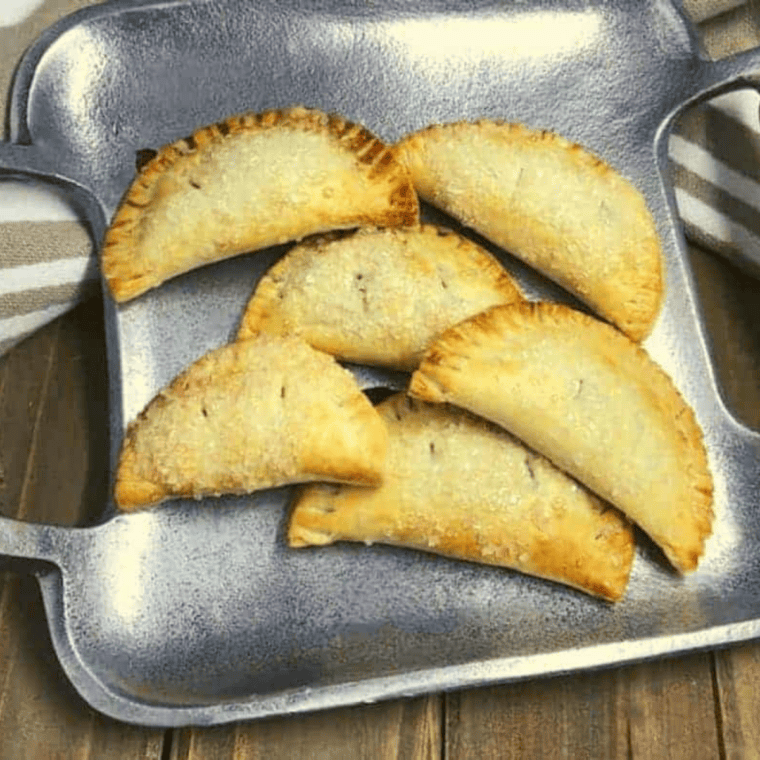 Golden air fryer blueberry hand pies with flaky crust, juicy blueberry filling, and vanilla glaze