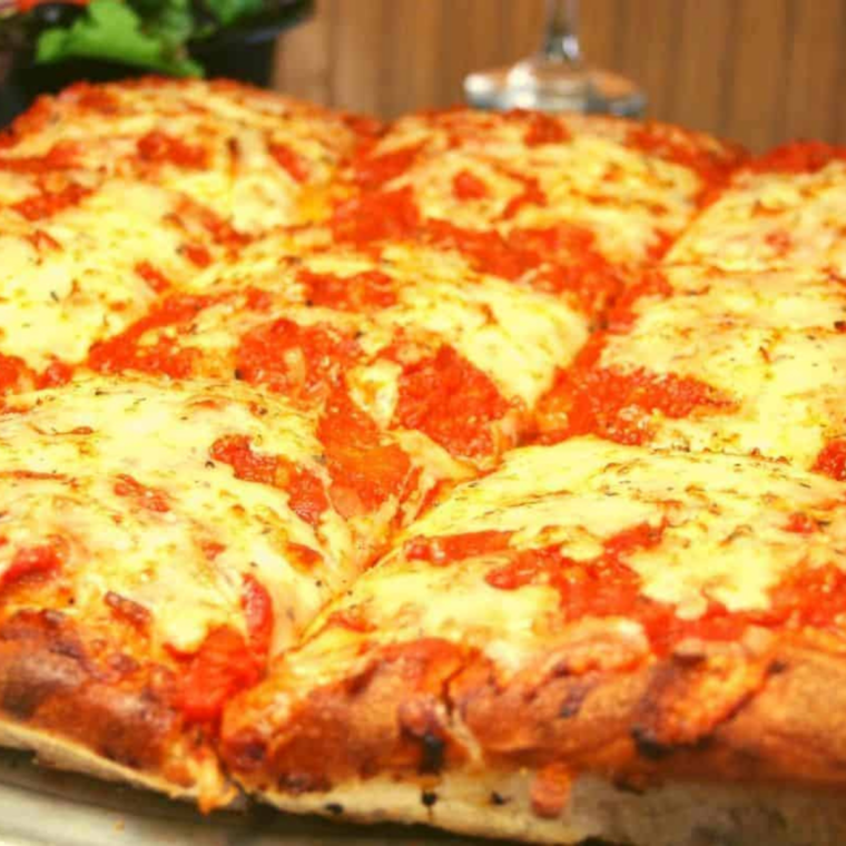 Finished Chicago style deep dish pizza removed from the springform pan showing the golden buttered crust wall.
