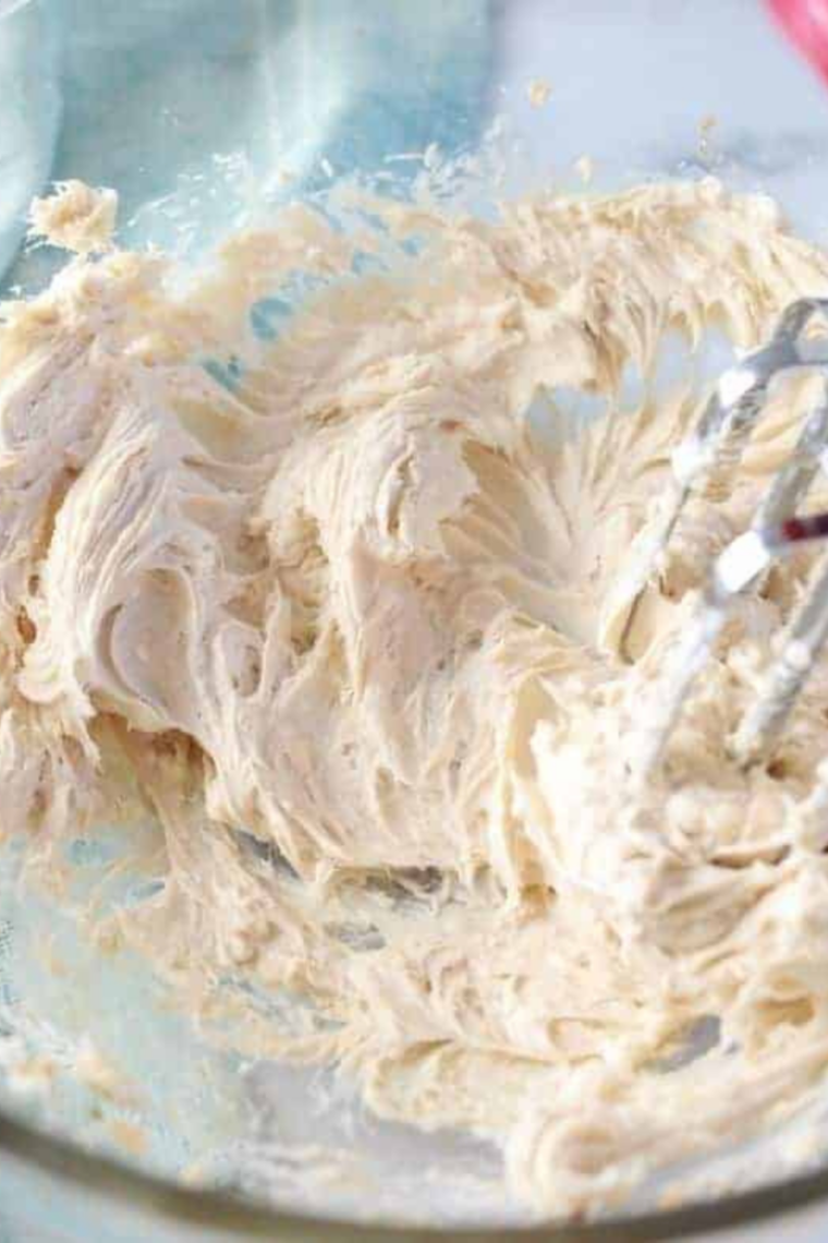 Softened cream cheese mixed with sugar and lemon extract until smooth and creamy in bowl.
