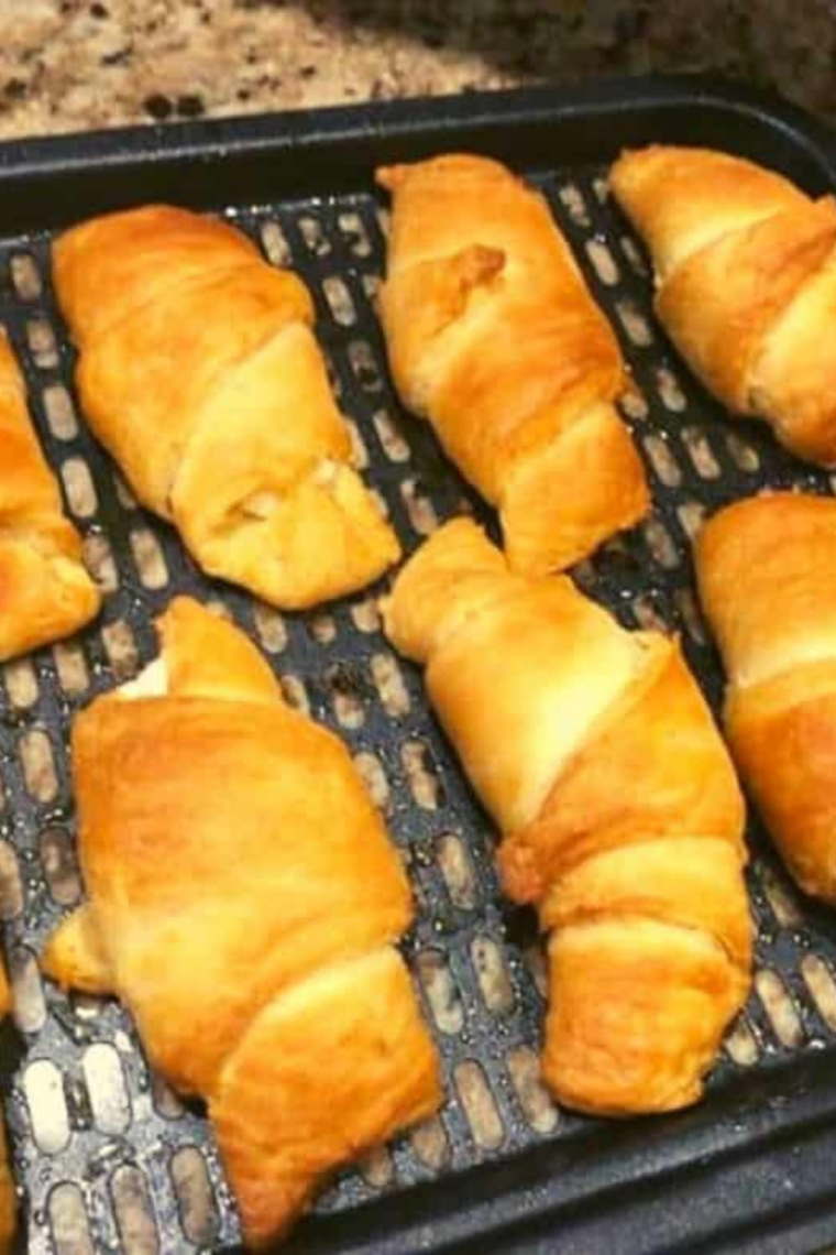 Crescent rolls arranged in air fryer basket ready for cooking at 340&deg;F.