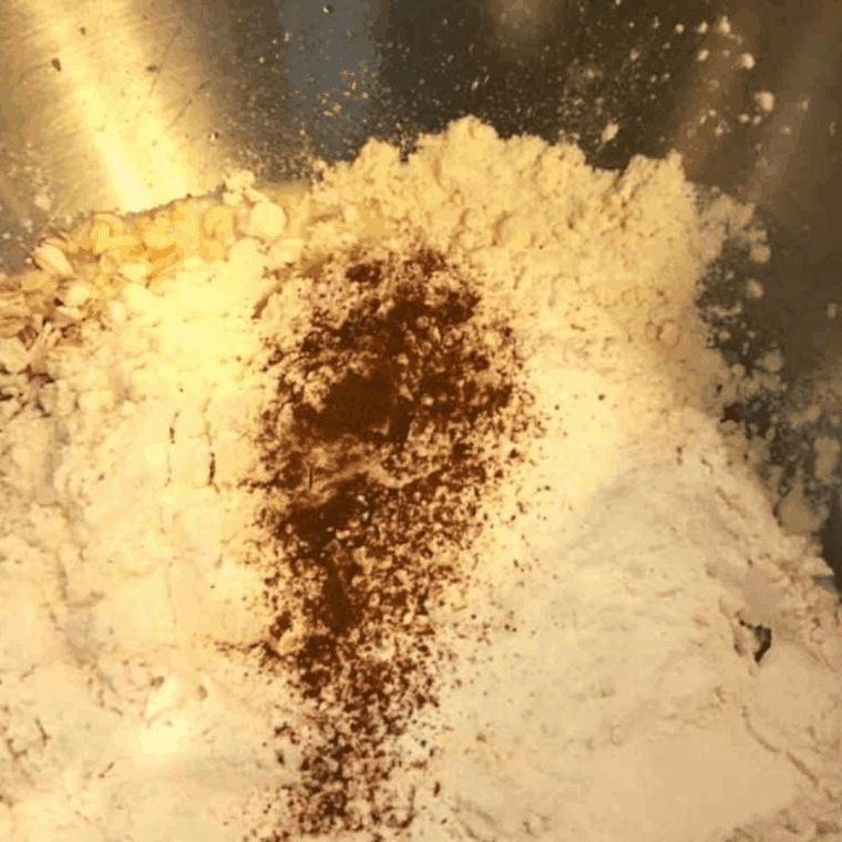 Mixing oats, milk, maple syrup, oil, brown sugar, eggs, flour, baking powder, cinnamon, baking soda, and salt together in a bowl to make oatmeal muffin batter