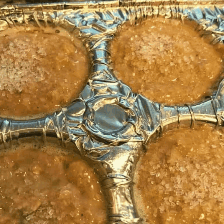 Filling greased muffin cups with maple brown sugar oatmeal batter and sprinkling sparkling sugar on top