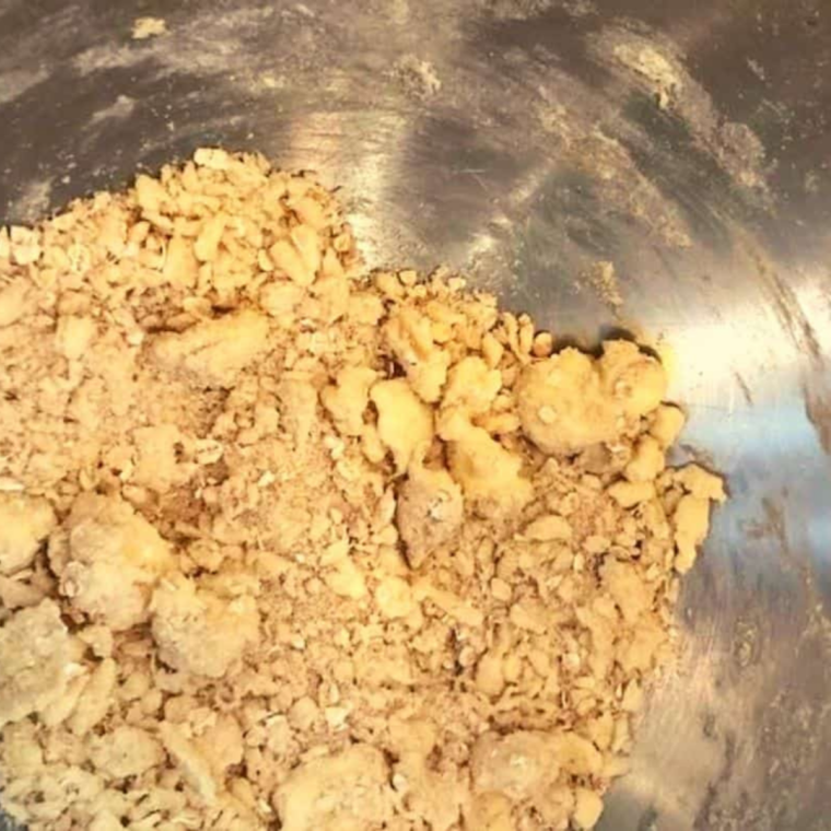 Mixing butter, brown sugar, and oats in a bowl to make crumbly streusel topping for English muffins.
