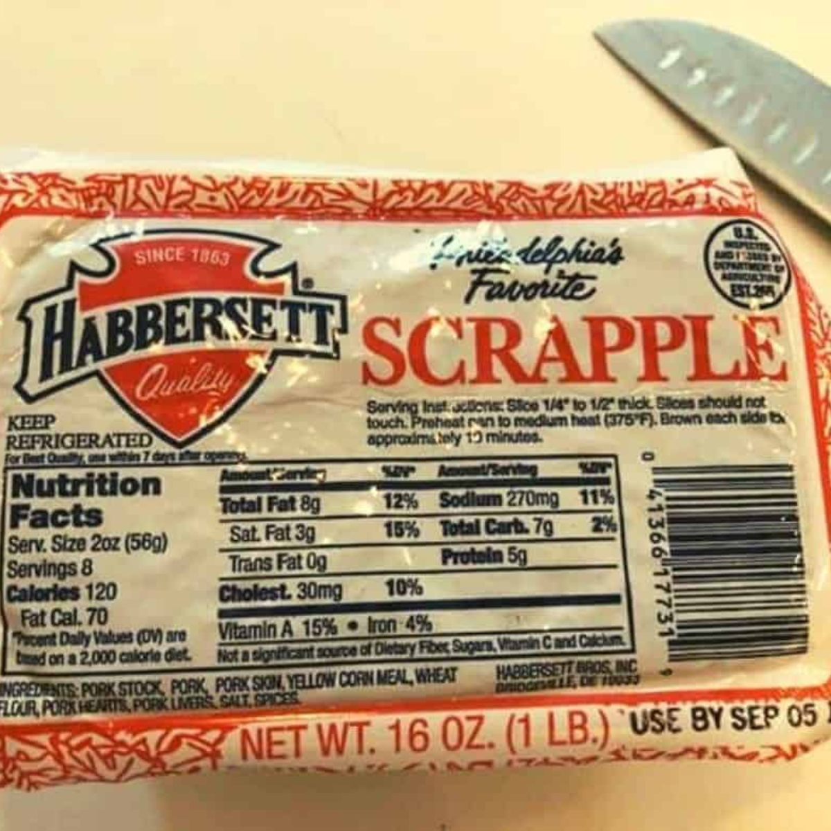 Package of scrapple and cooking oil spray on a wood cutting board