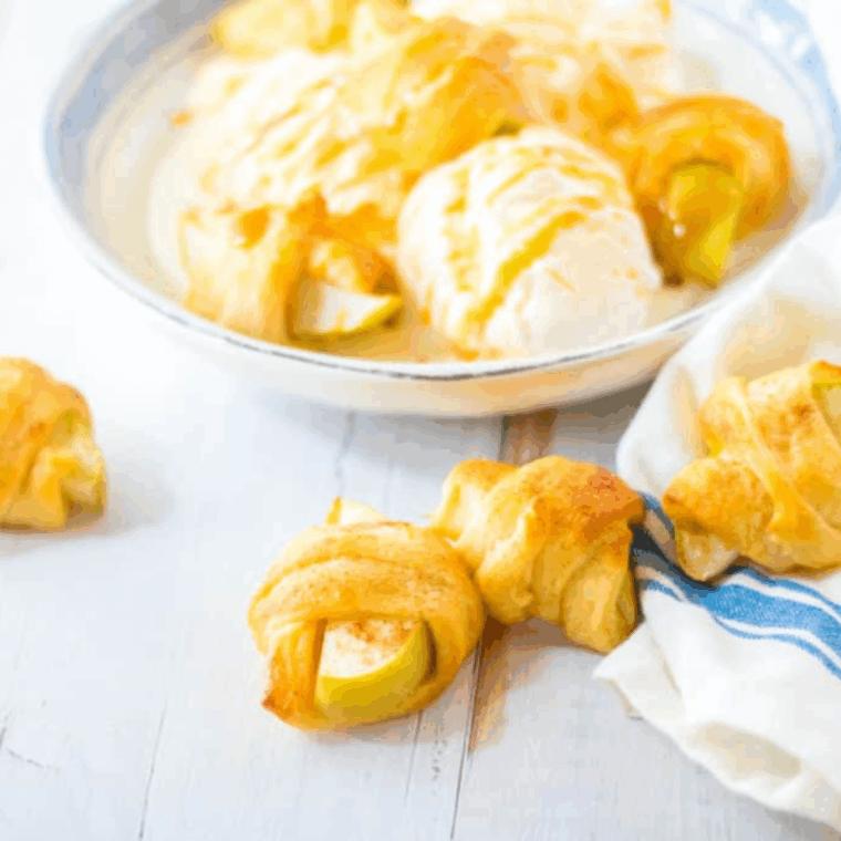Golden-brown Air Fryer Apple Pie Crescent Rolls served warm with caramel drizzle over ice cream.