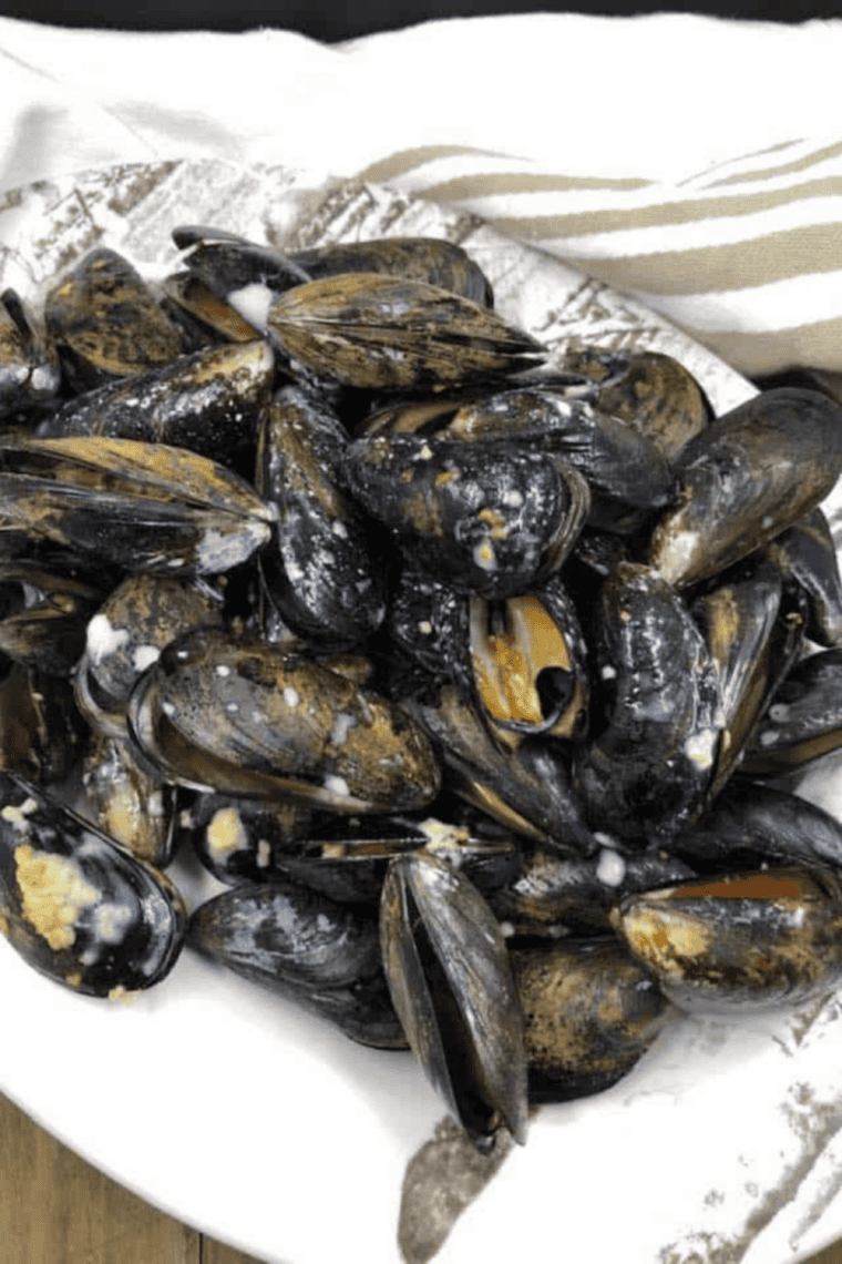 Air Fryer Classic French Mussels in creamy garlic butter sauce served in a white bowl, garnished with parsley.