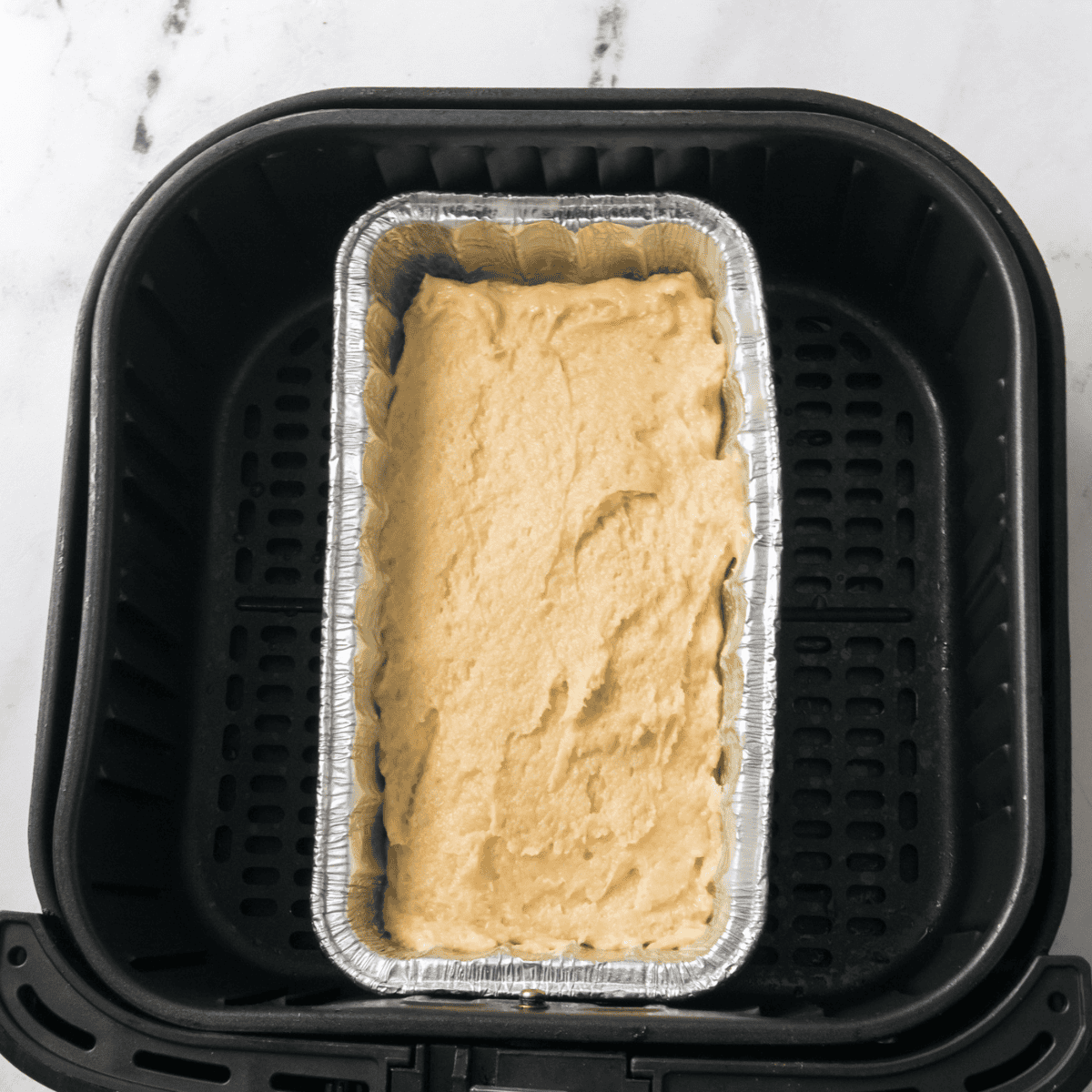 Mini loaf pans filled with pancake bread batter and crumb topping, ready to air fry until golden and cooled for slicing.