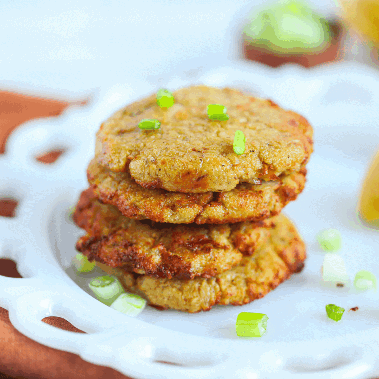 Air fryer tuna patties served on a plate with lemon and herbs