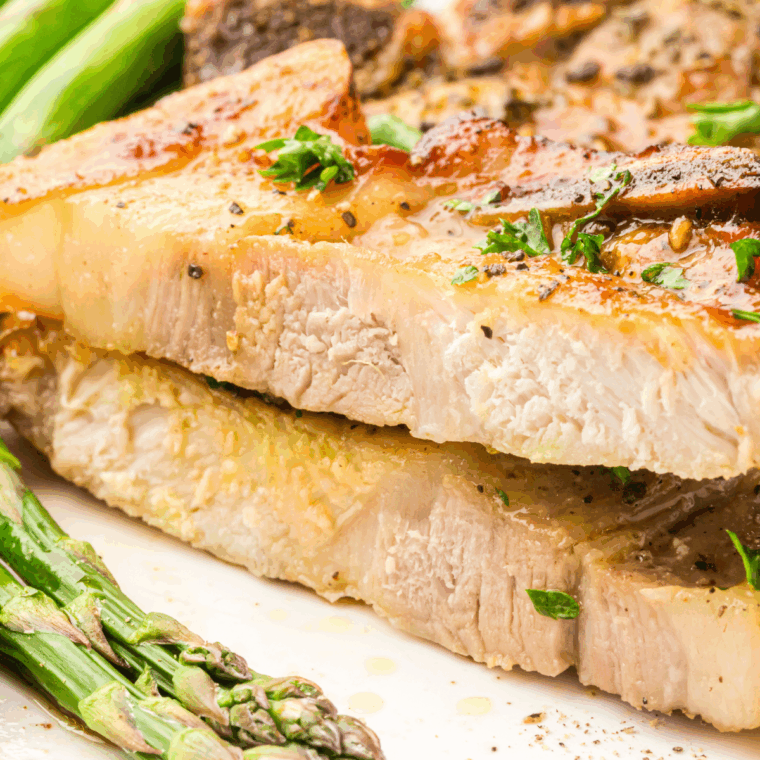 Juicy Mexican pork chops served with fresh herbs and lime wedges