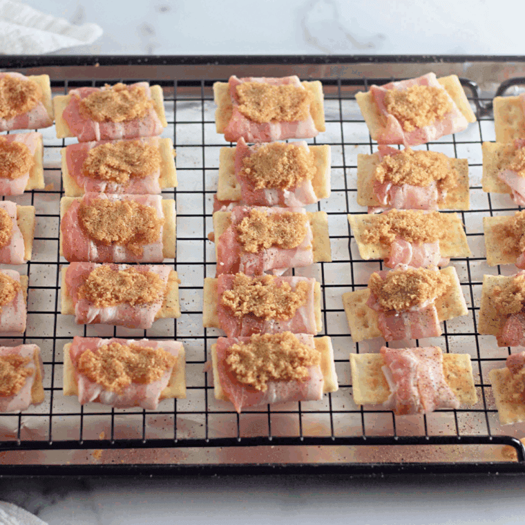 Wrap each cheese-topped cracker with bacon and place in air fryer basket, then air fry at 400°F for 8-12 minutes.