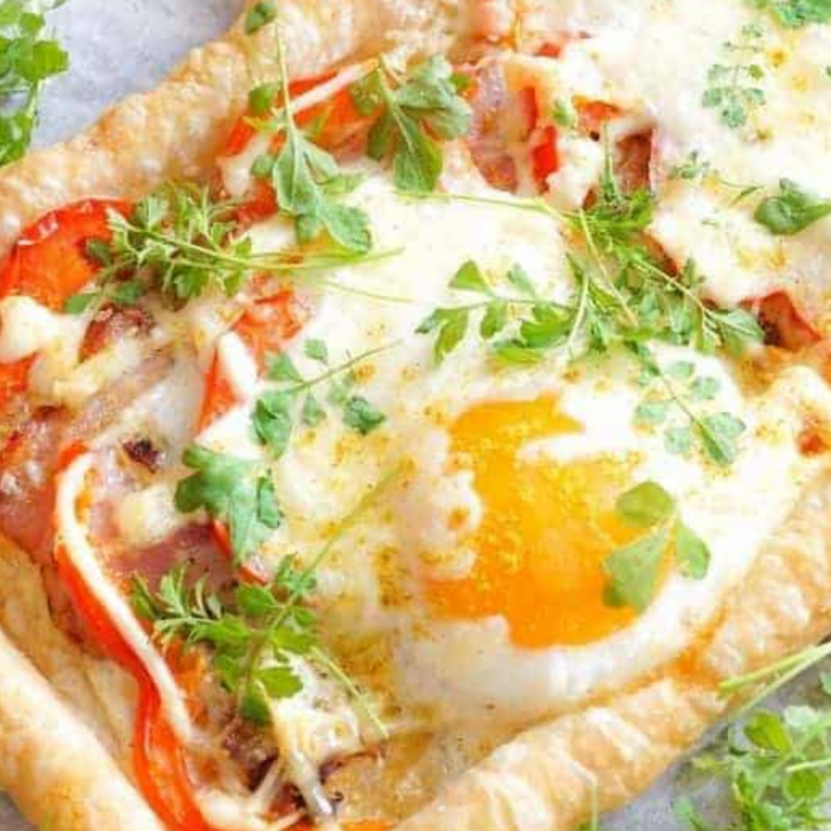 Finished squares on a plate with herbs. Alt text: "Air fryer bacon and egg crescent squares plated with fresh chives and a side of fruit.