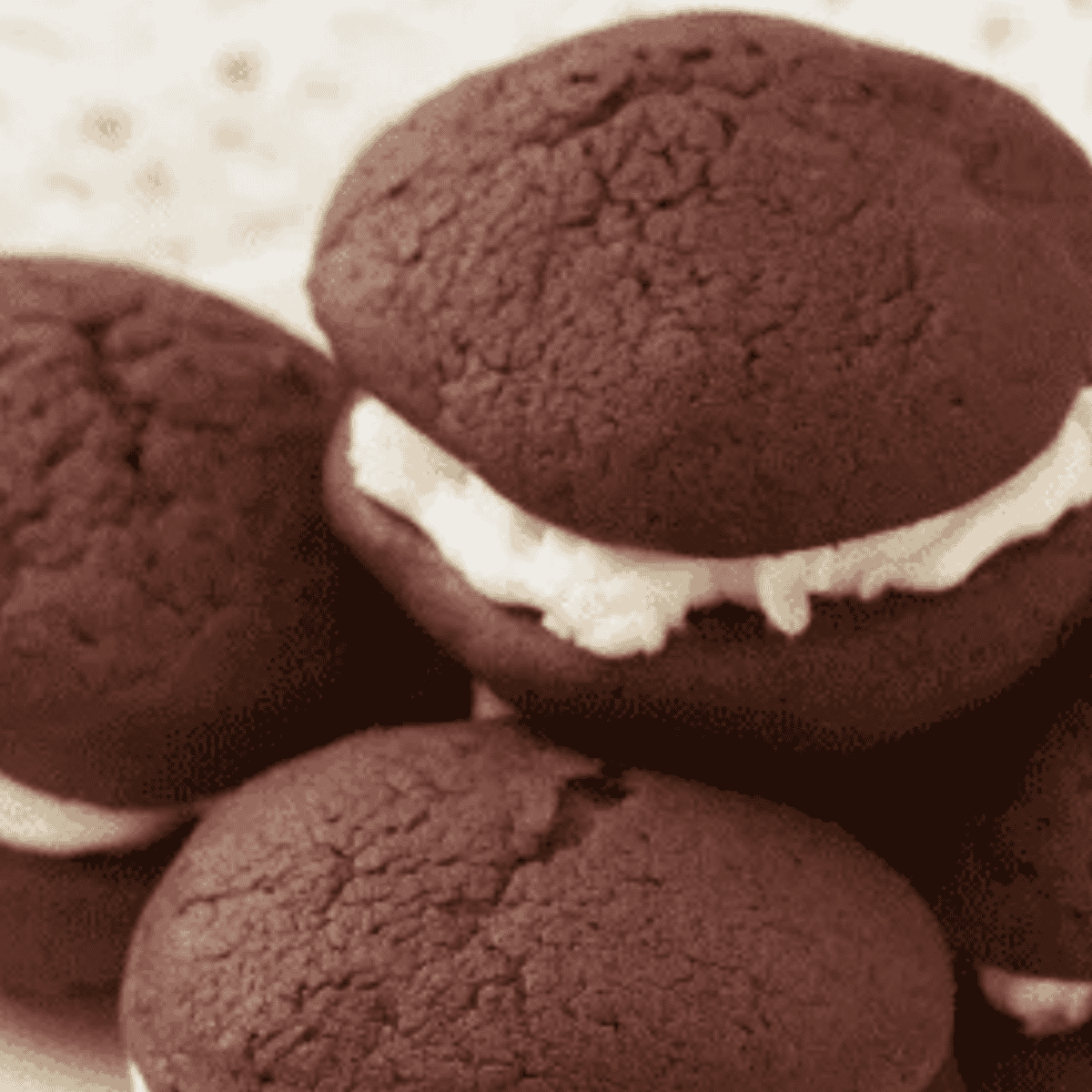 Stack of air fryer chocolate whoopie pies with marshmallow filling on a white plate